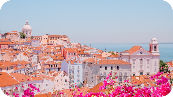 Historic Portuguese tram on cobblestone streets with coastal views, Lisbon